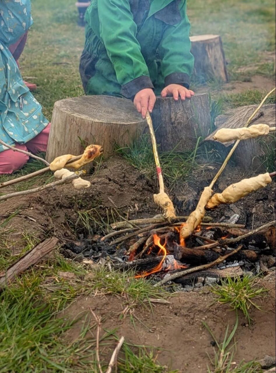 Children cooking over an open campfire at forest school
